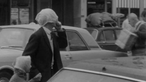 A man and his daughter use their handkerchiefs as headgear to fend off rain in Cork, 1969. A man and his daughter use their handkerchiefs as headgear to fend off rain in Cork, 1969.