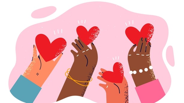 Hearts in hands of people of different races and nationalities symbolize kindness