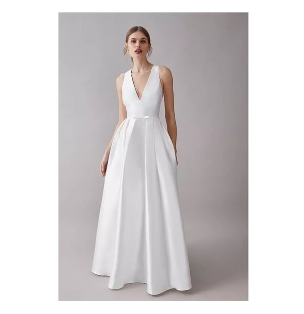 Model wears v-neck a-line satin white sleeveless gown